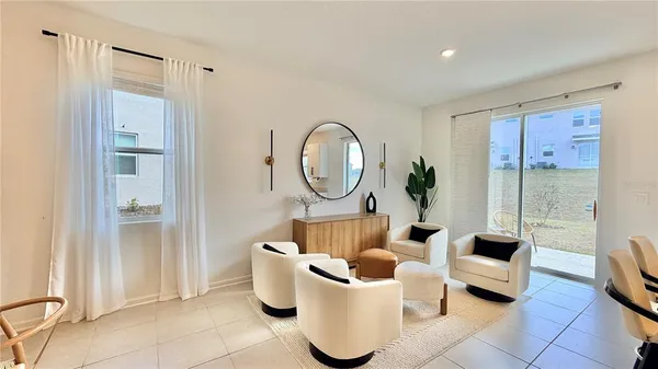 a living room with furniture a large window and a mirror
