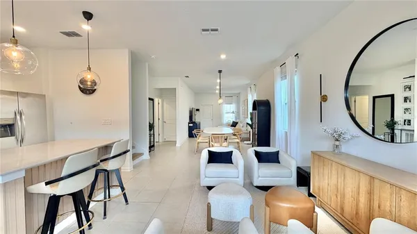 a living room with furniture a mirror and a chandelier