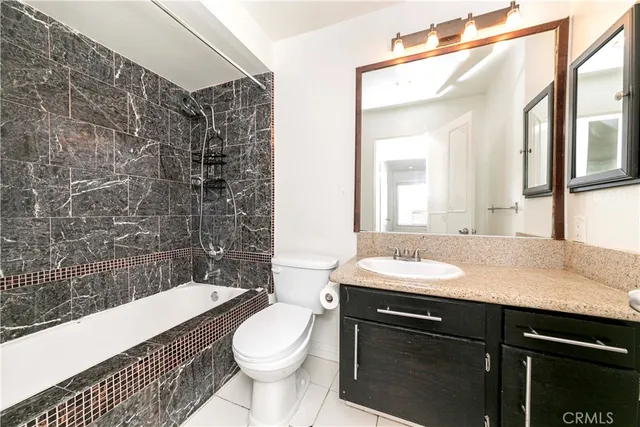 a bathroom with a granite countertop sink toilet a mirror and shower