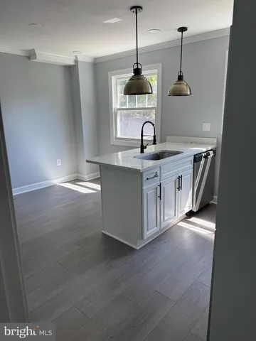 a kitchen with stainless steel appliances a sink a stove a refrigerator and cabinets