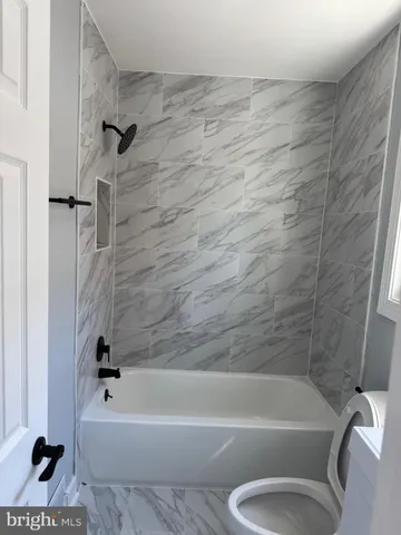 a bathroom with a toilet bathtub and shower