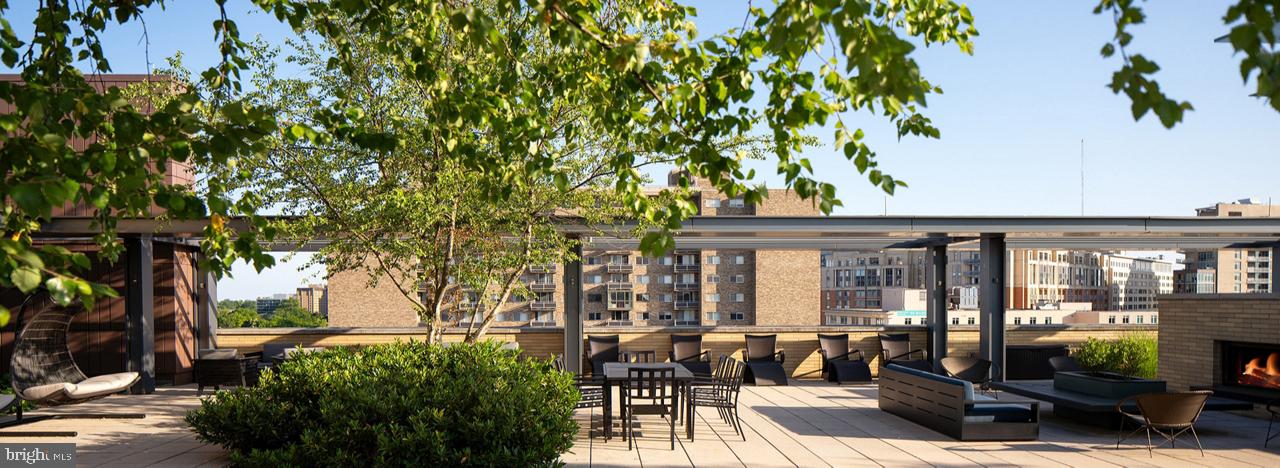 8300 Wisconsin Avenue, Unit 1B1447 Bethesda, MD 20814 - Photo 23 of 25 a view of a patio with couches table and chairs potted plants and large tree