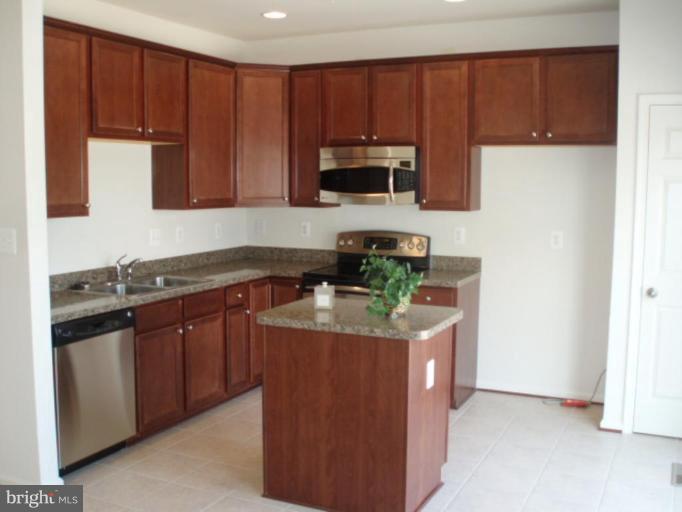 8170 Mission Road Jessup, MD 20794 - Photo 3 of 12 a kitchen with stainless steel appliances granite countertop a stove a sink and a microwave