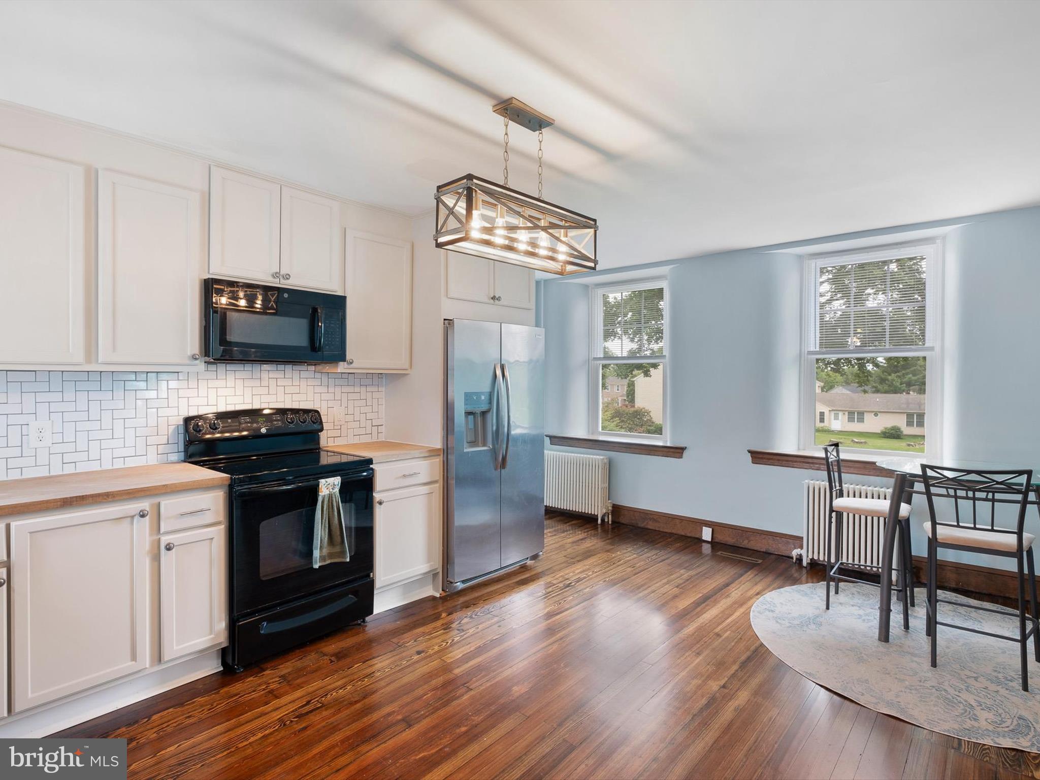 5961 Limestone Road Hockessin, DE 19707 - Photo 12 of 40 a kitchen with stainless steel appliances a stove a sink dishwasher a dining table and chairs with wooden floor