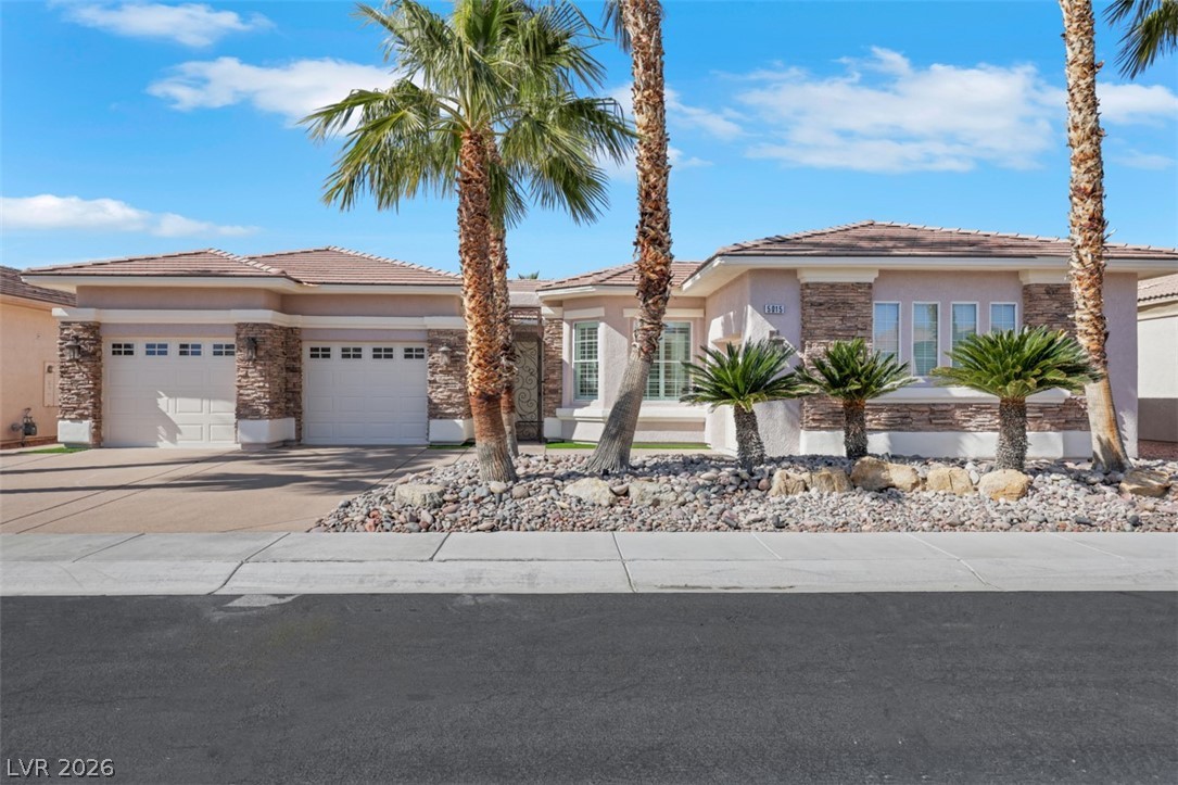 5015 Rivedro Street Las Vegas, NV 89135 - Photo 65 of 91 A desert-friendly facade with stone accents and a pair of two-car garages.