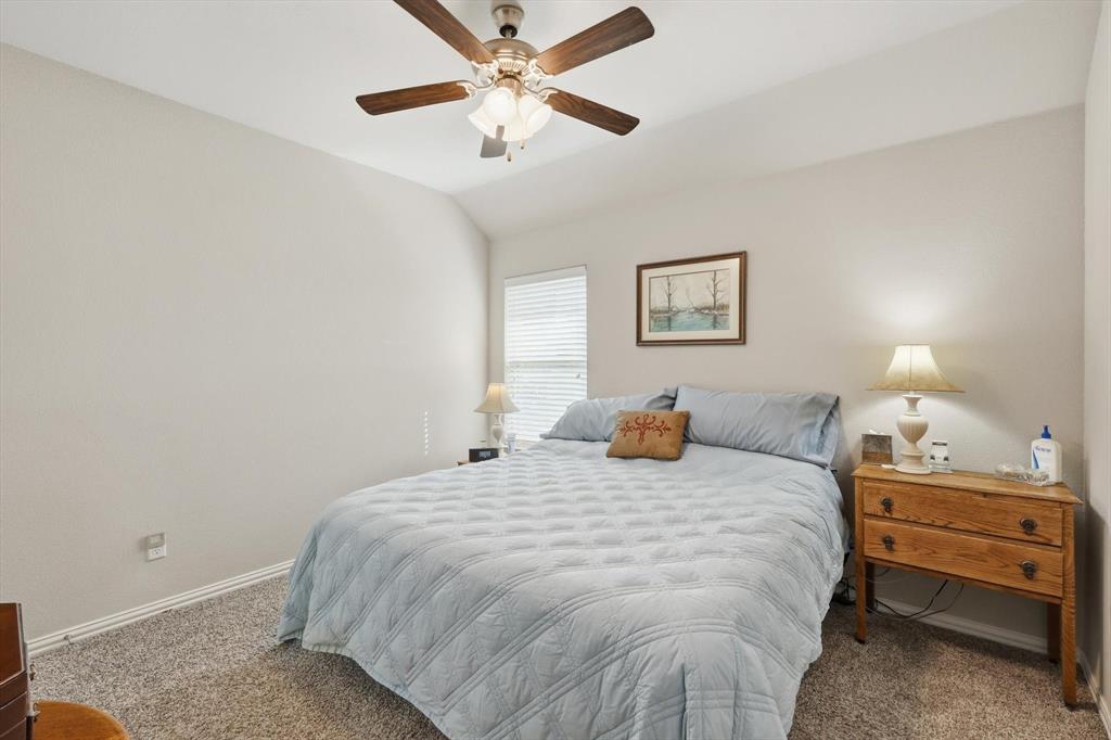 113 Heather Lane Decatur, TX 76234 - Photo 23 of 32 a bedroom with a bed and a chandelier