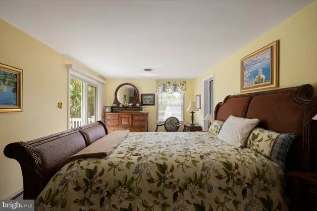 a bedroom with a bed and dresser with mirror