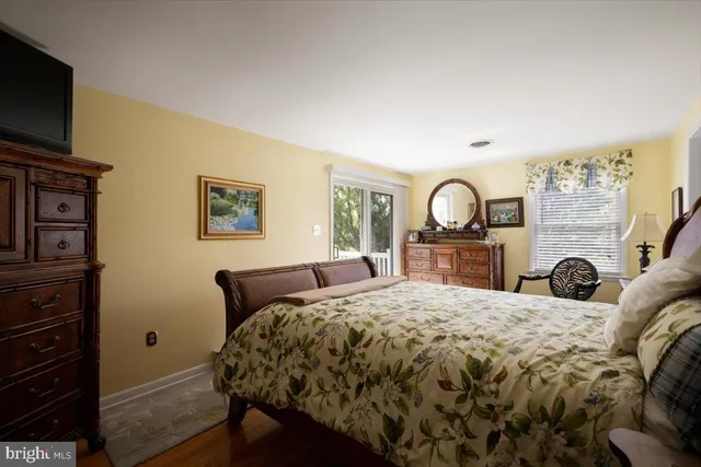 a large bedroom with a bed and a flat tv screen on dresser