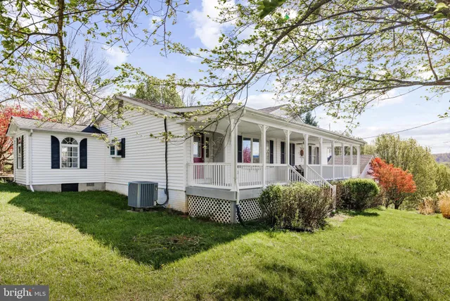 a view of a house with a yard and sitting area