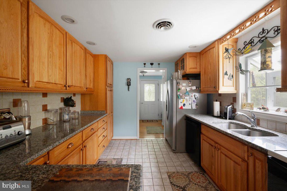 1049 Laurel Grove Road Winchester, VA 22602 - Photo 8 of 42 a kitchen with stainless steel appliances granite countertop a refrigerator a sink dishwasher and wooden cabinets