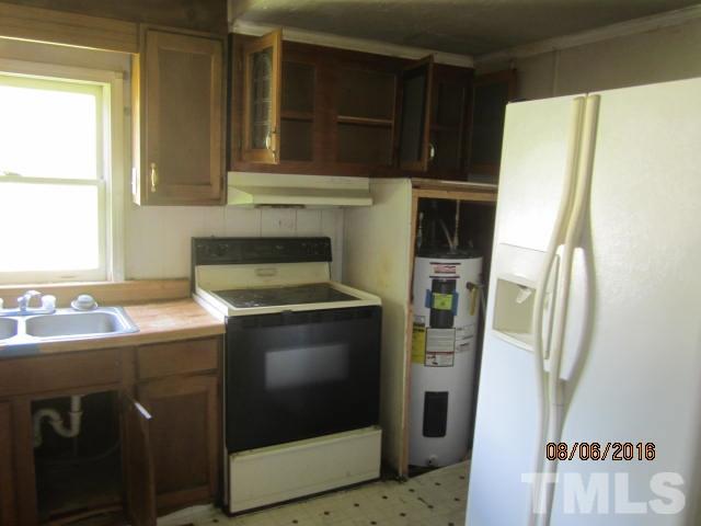 2543 Leasburg Road Roxboro, NC 27574 - Photo 10 of 18 a kitchen with a refrigerator sink and cabinets