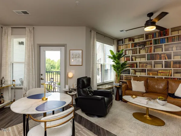 a living room with furniture a flat screen tv and a large window
