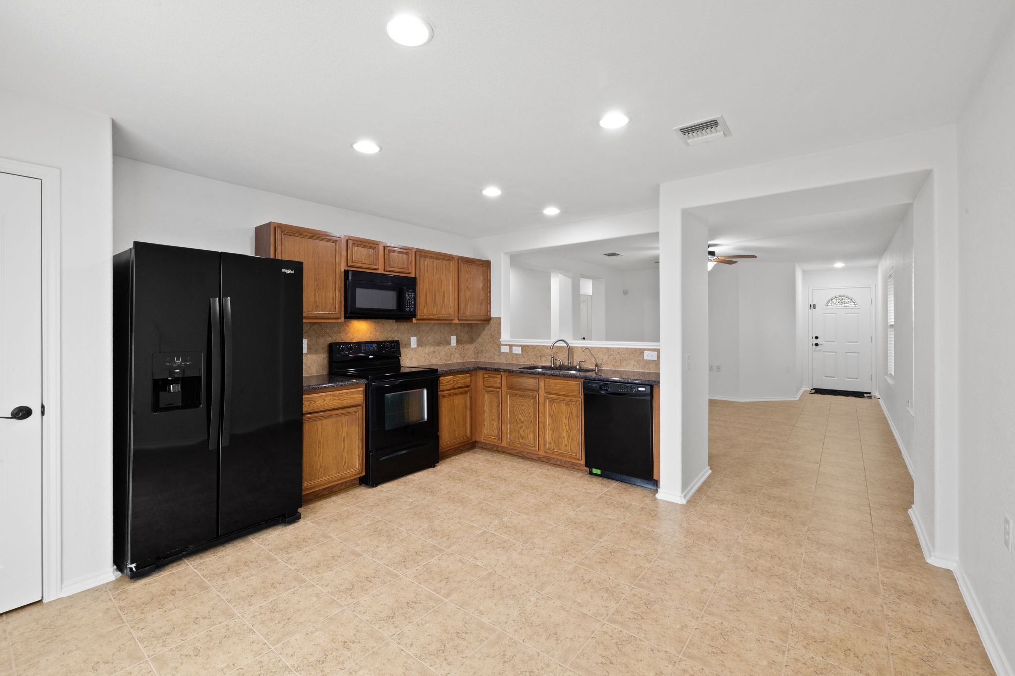 8825 Stambourne Street Austin, TX 78747 - Photo 11 of 37 a kitchen with a refrigerator and a sink