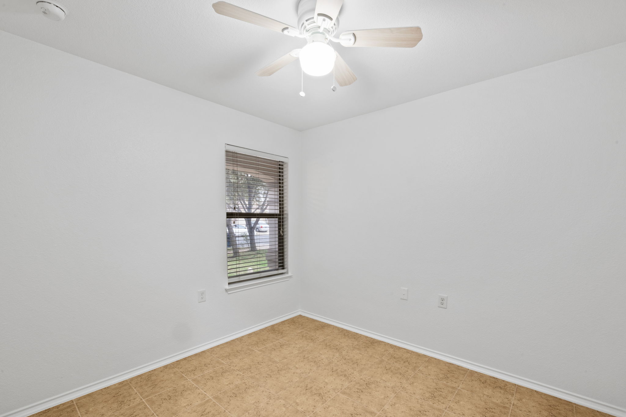 8825 Stambourne Street Austin, TX 78747 - Photo 17 of 37 an empty room with a chandelier fan and windows
