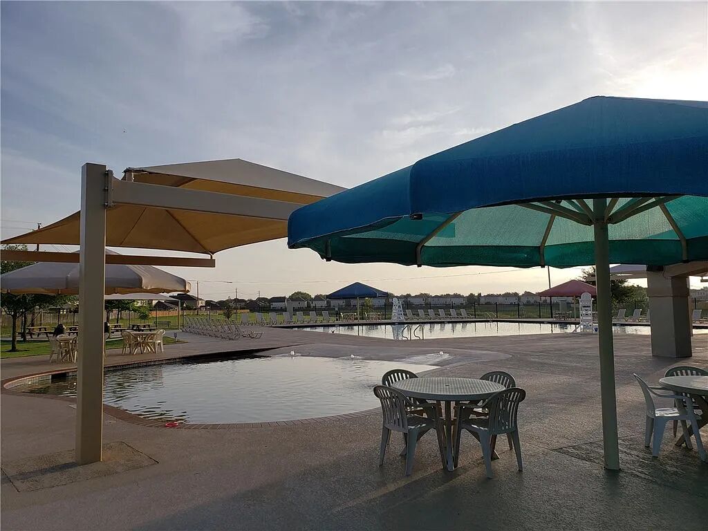 8825 Stambourne Street Austin, TX 78747 - Photo 33 of 37 a view of a patio with a table and chairs under an umbrella
