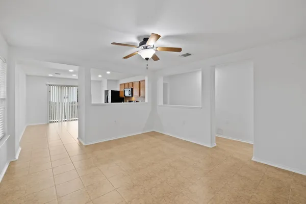 an empty room with closet and a ceiling fan