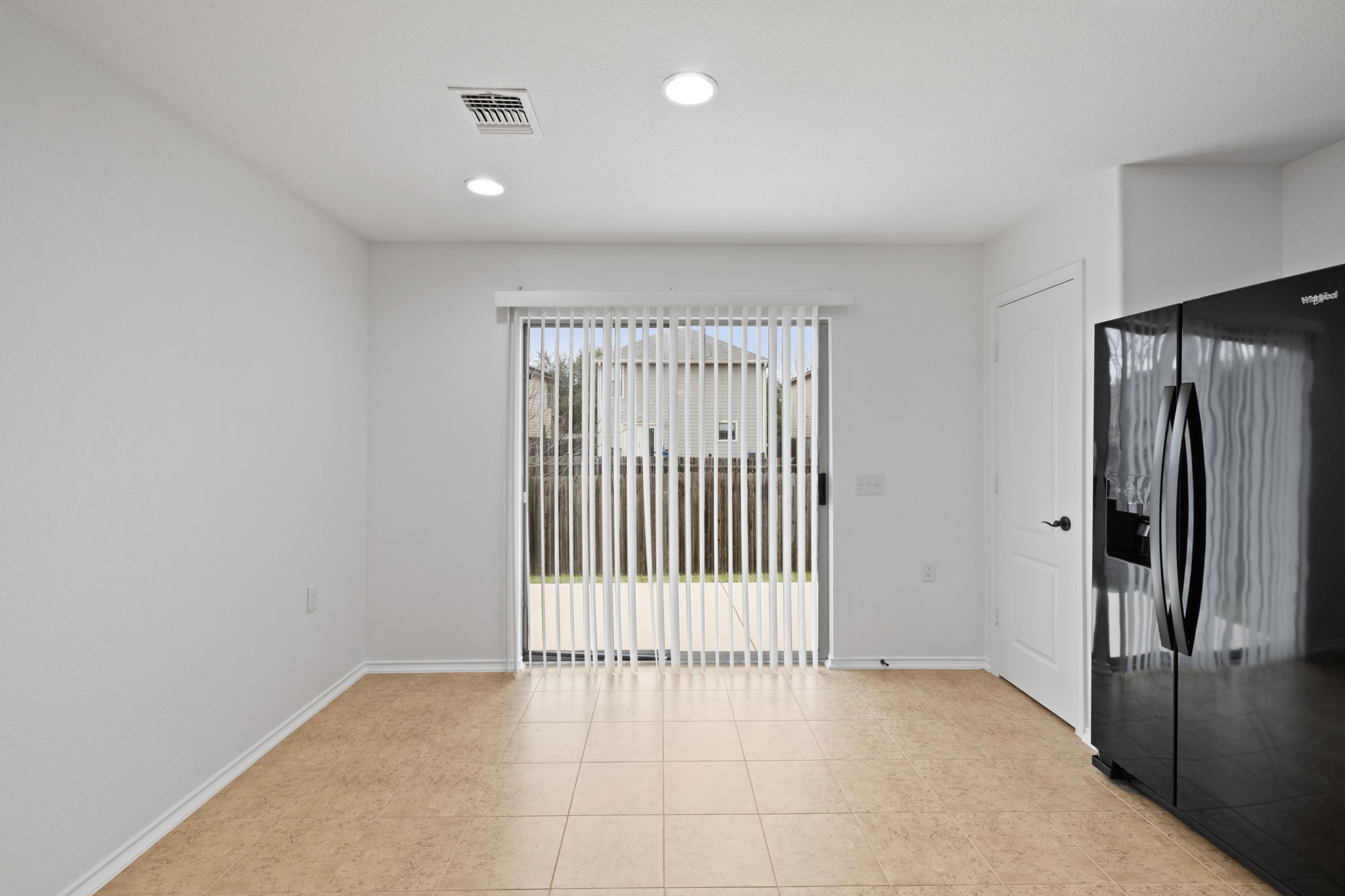 8825 Stambourne Street Austin, TX 78747 - Photo 9 of 37 Unfurnished bedroom featuring black fridge, a pantry, recessed lighting, and access to outside
