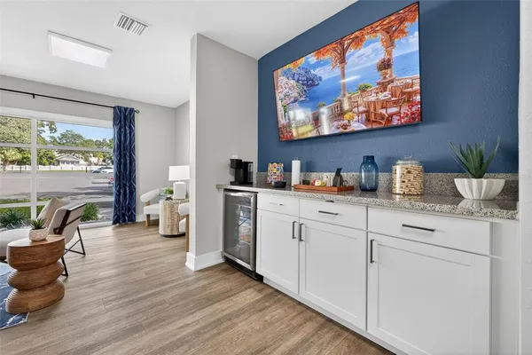 a kitchen with stainless steel appliances white cabinets and wooden floor