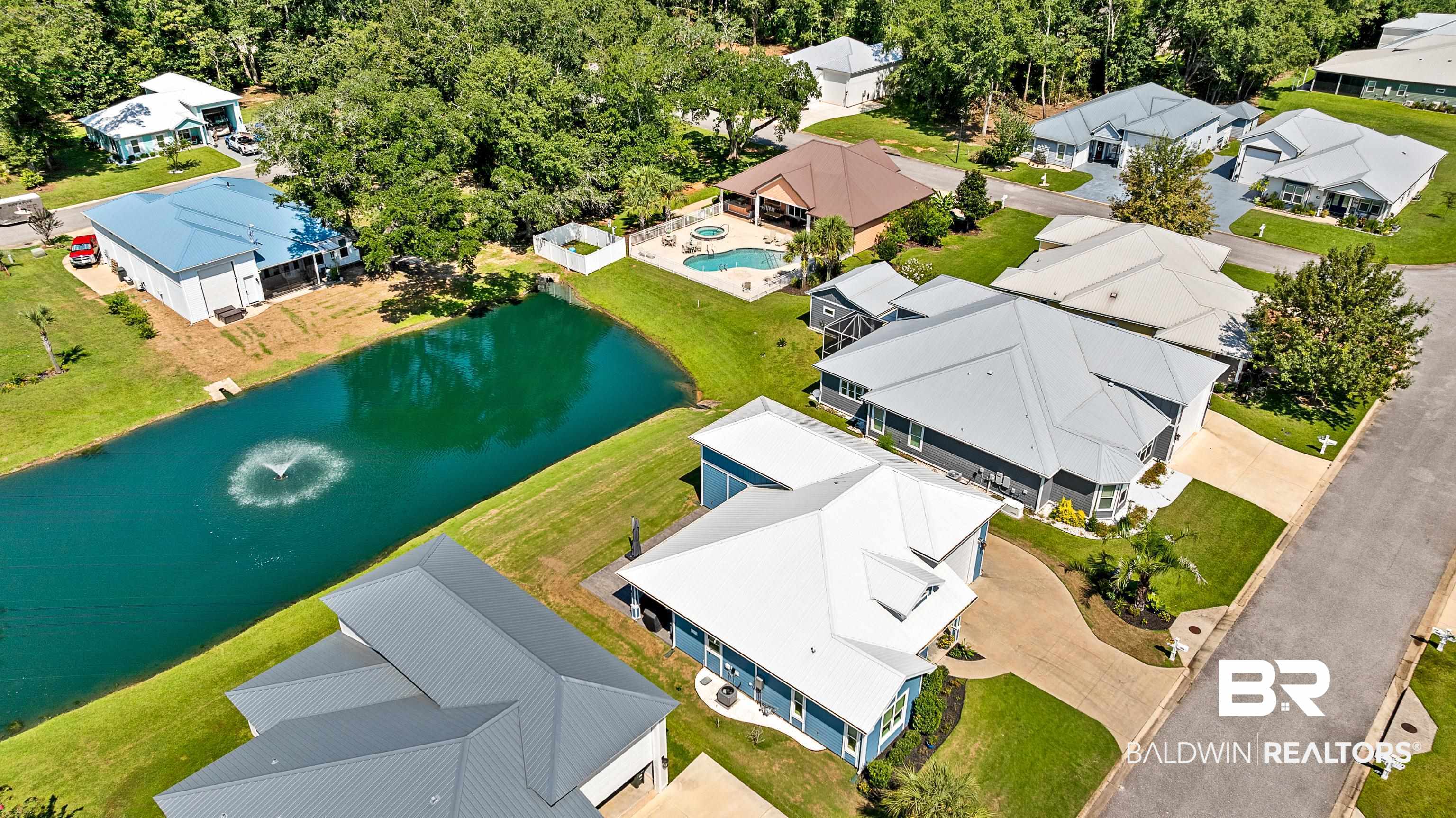 12329 Reunion Place, Unit LOT 38 Foley, AL 36535 - Photo 36 of 43 Aerial perspective of suburban area with a large body of water and a pool