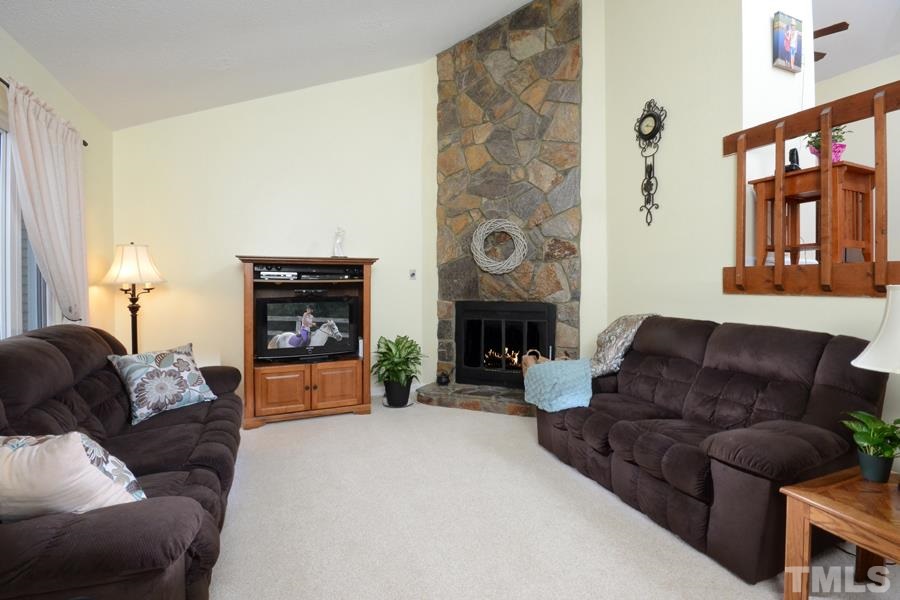 2401 Boothbay Court Raleigh, NC 27613 - Photo 5 of 21 with feature stone wood burning fireplace, ample natural light and airy feel.