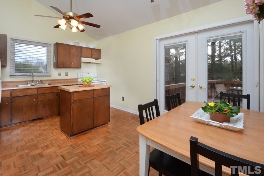 2401 Boothbay Court Raleigh, NC 27613 - Photo 7 of 21 with double doors leading to deck overlooking landscaped backyard