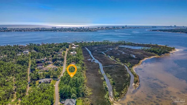 an aerial view of a house with a yard and lake view