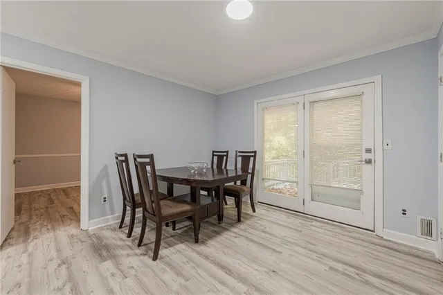 a view of an empty room with wooden floor and window