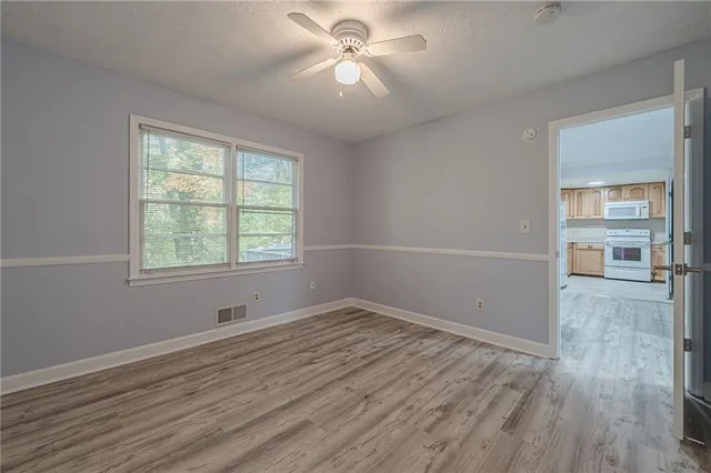 an empty room with wooden floor and windows