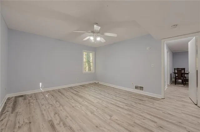 a view of an empty room with wooden floor