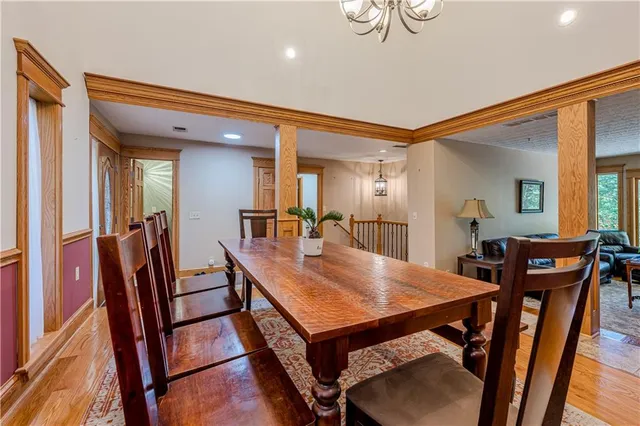 a view of a dining room with furniture a chandelier and wooden floor
