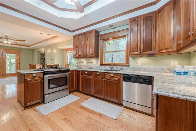 a kitchen with stainless steel appliances granite countertop a refrigerator and a stove