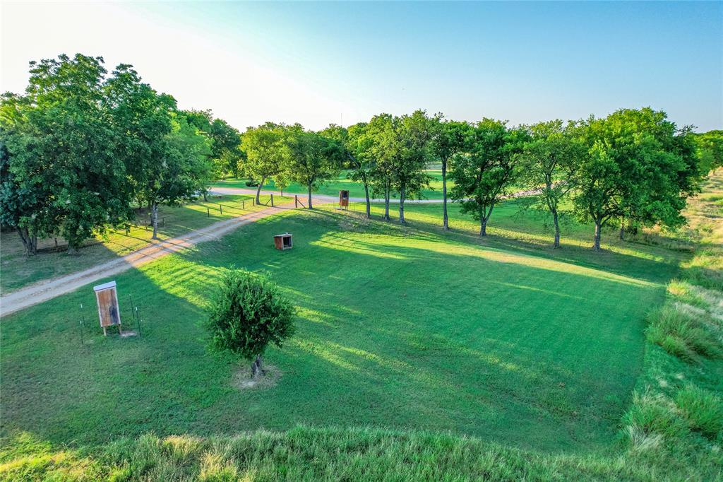 1922 A Bethel-Cannon Road Whitewright, TX 75491 - Photo 23 of 40 Expansive green lawn with a tree-lined perimeter and natural foliage at the property edge
