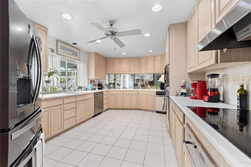 6937 Midnight Pass Road Sarasota, FL 34242 - Photo 11 of 30 a kitchen with a sink refrigerator and cabinets