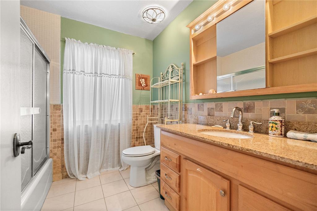 6937 Midnight Pass Road Sarasota, FL 34242 - Photo 14 of 30 a bathroom with a granite countertop sink and a mirror