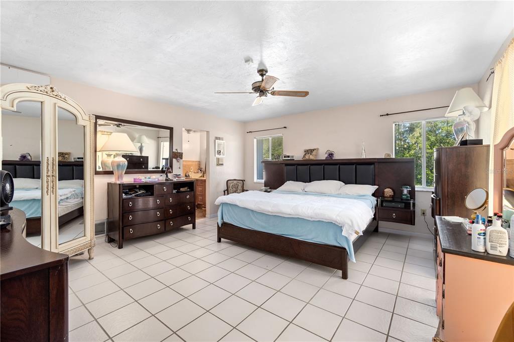6937 Midnight Pass Road Sarasota, FL 34242 - Photo 17 of 30 a spacious bedroom with a bed a couch and dresser