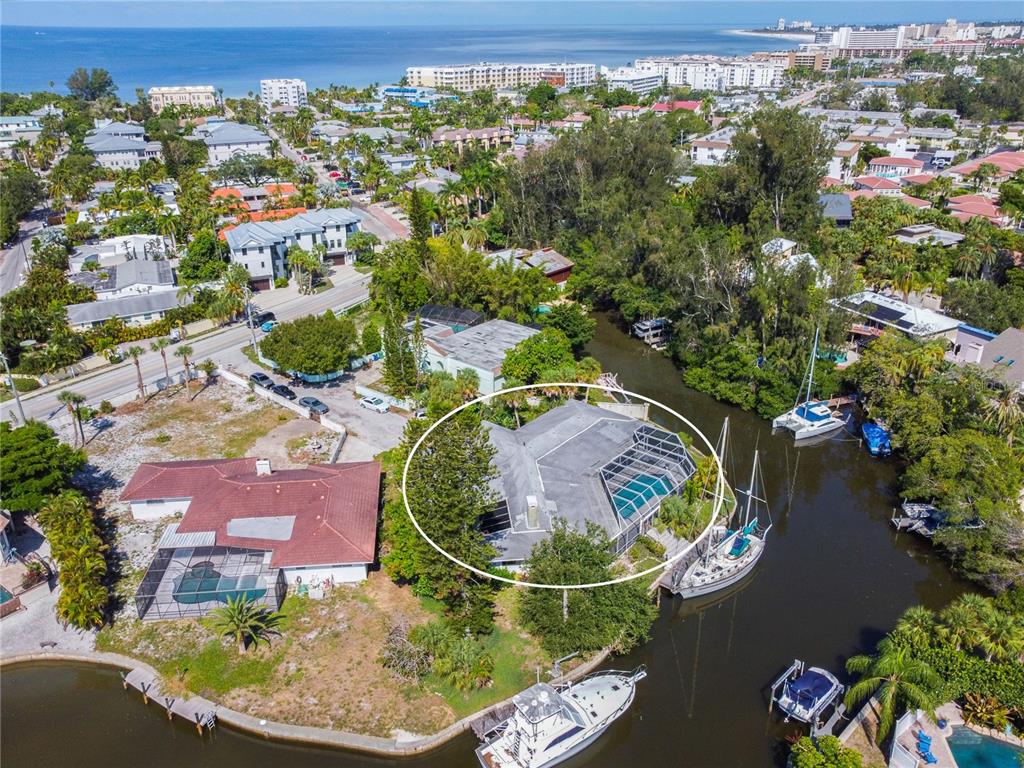 6937 Midnight Pass Road Sarasota, FL 34242 - Photo 26 of 30 an aerial view of a house with a swimming pool a yard and a lake view