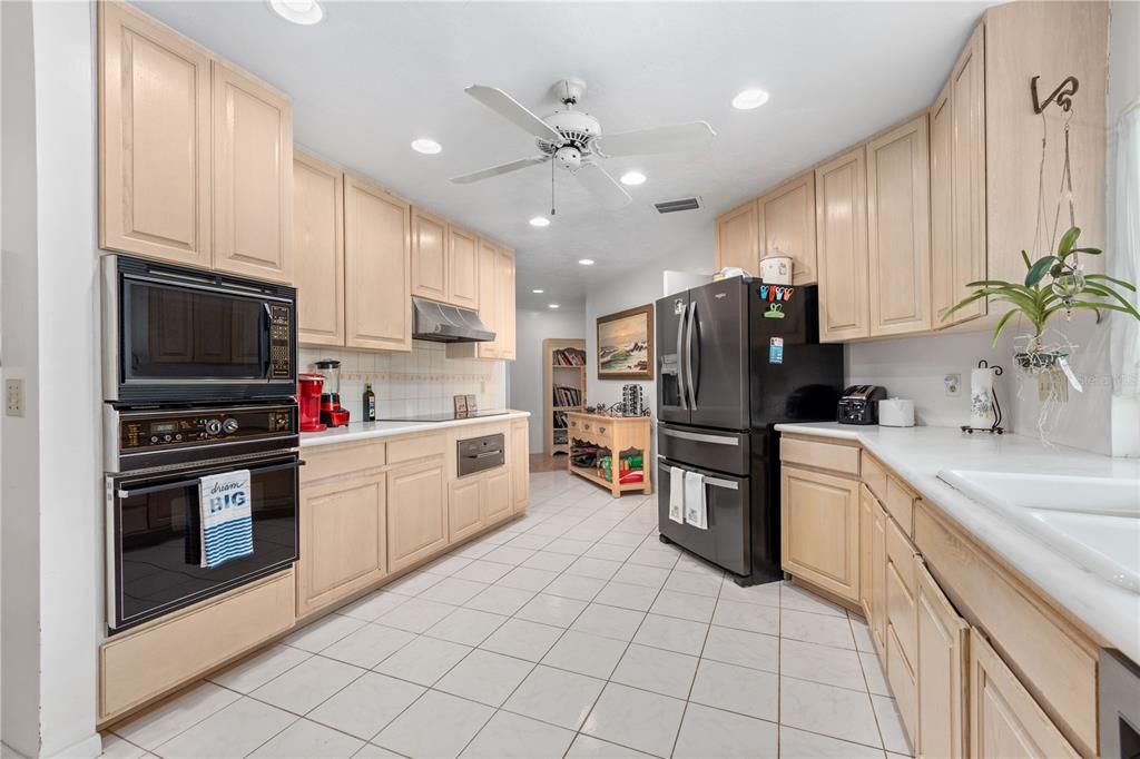 6937 Midnight Pass Road Sarasota, FL 34242 - Photo 10 of 30 a kitchen with a sink cabinets and stainless steel appliances