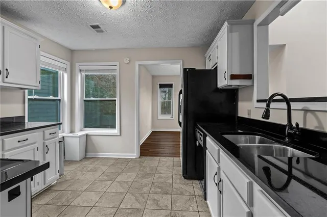 a kitchen with granite countertop a stove sink and cabinets