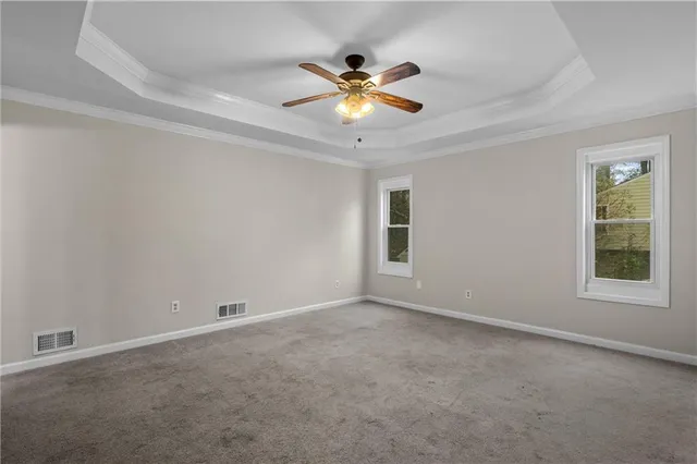 a view of an empty room with a ceiling fan and window