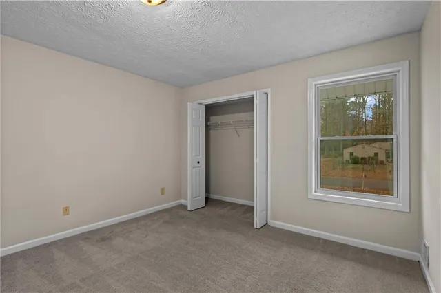 an empty room with windows and closet