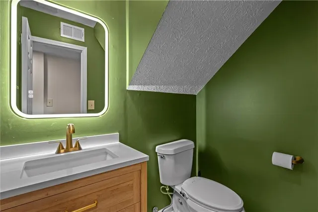 a bathroom with a toilet sink and mirror