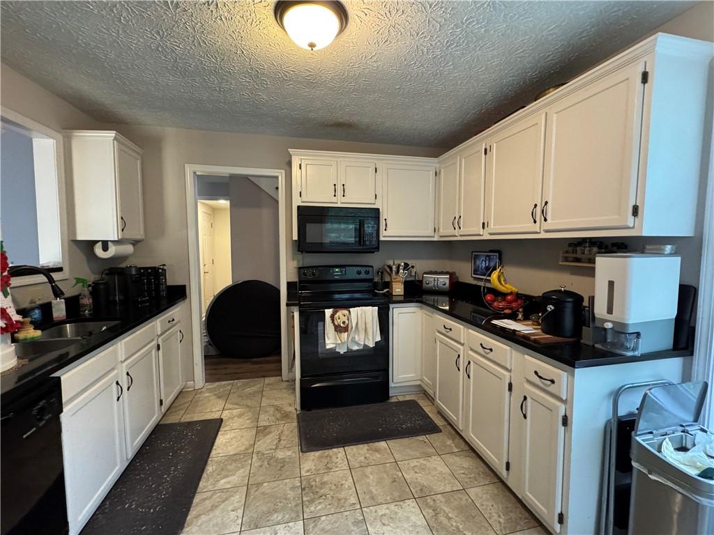 2400 Salem Drive Marietta, GA 30062 - Photo 6 of 16 a kitchen with stainless steel appliances granite countertop a stove sink microwave and cabinets
