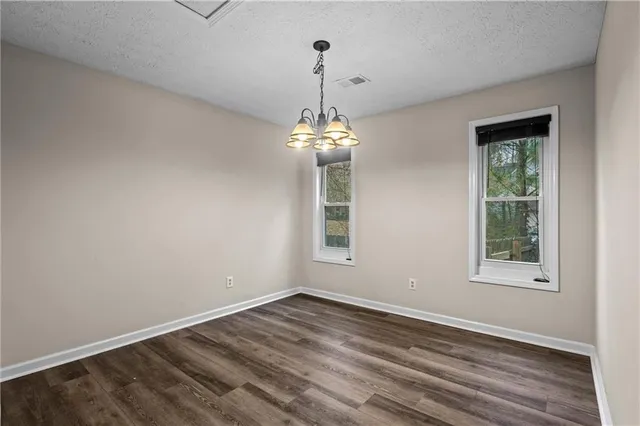 a view of a room with wooden floor and windows