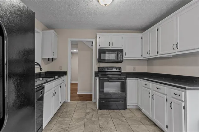 a kitchen with granite countertop a refrigerator and a sink