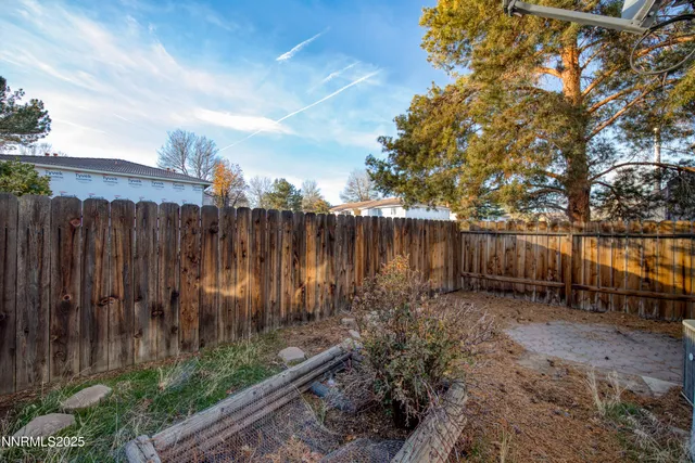 a view of a backyard with wooden fence
