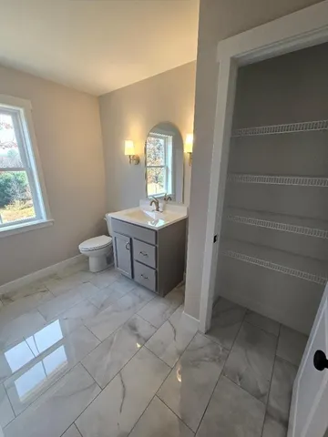 a bathroom with a sink toilet and window