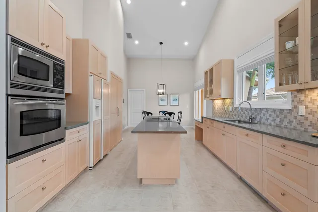 a kitchen with stainless steel appliances granite countertop a sink and a refrigerator