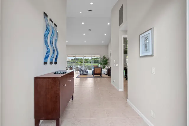 a view of a hallway with wooden floor and a living room