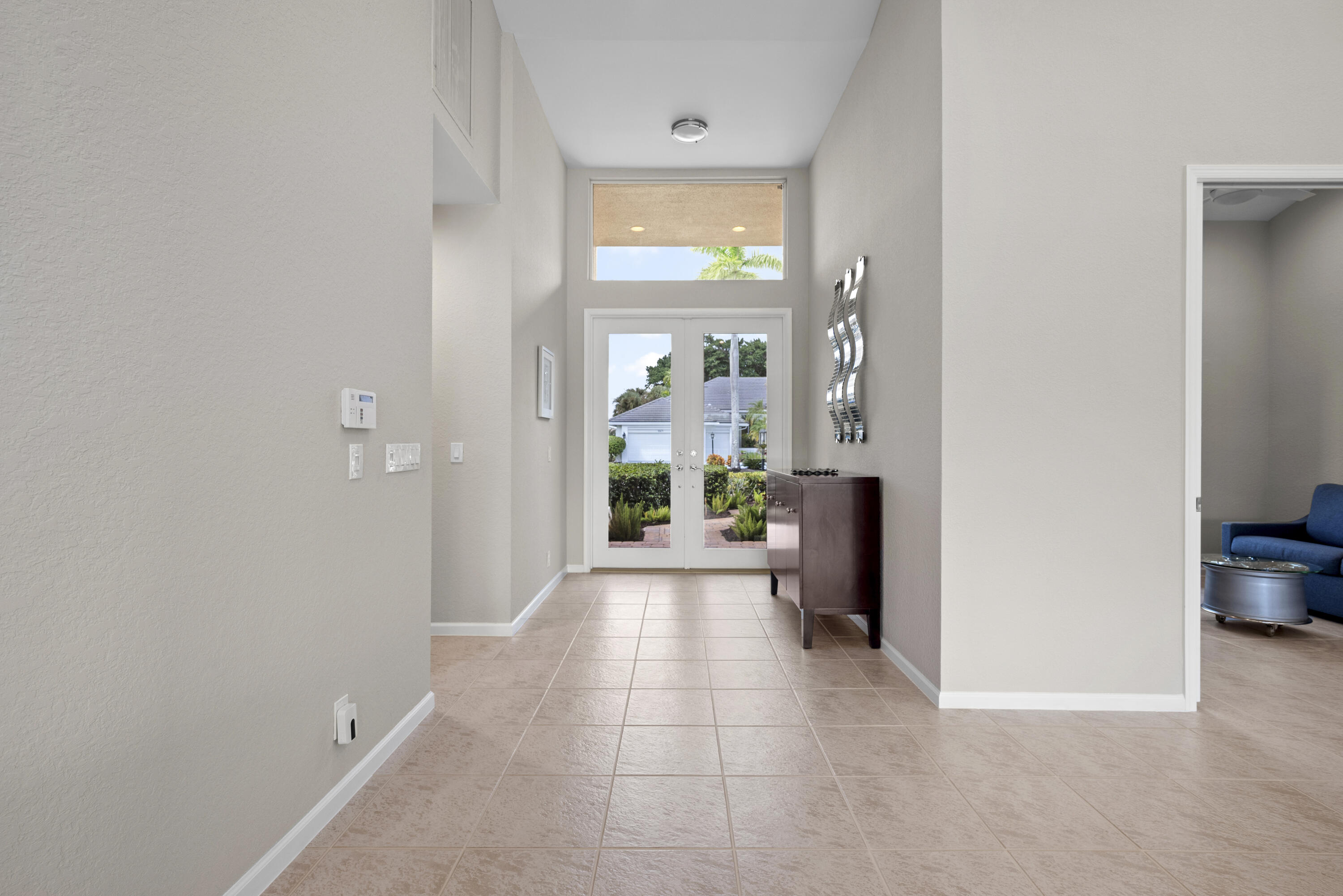 10670 Stonebridge Boulevard Boca Raton, FL 33498 - Photo 10 of 58 a view of a hallway with wooden floor and a living room