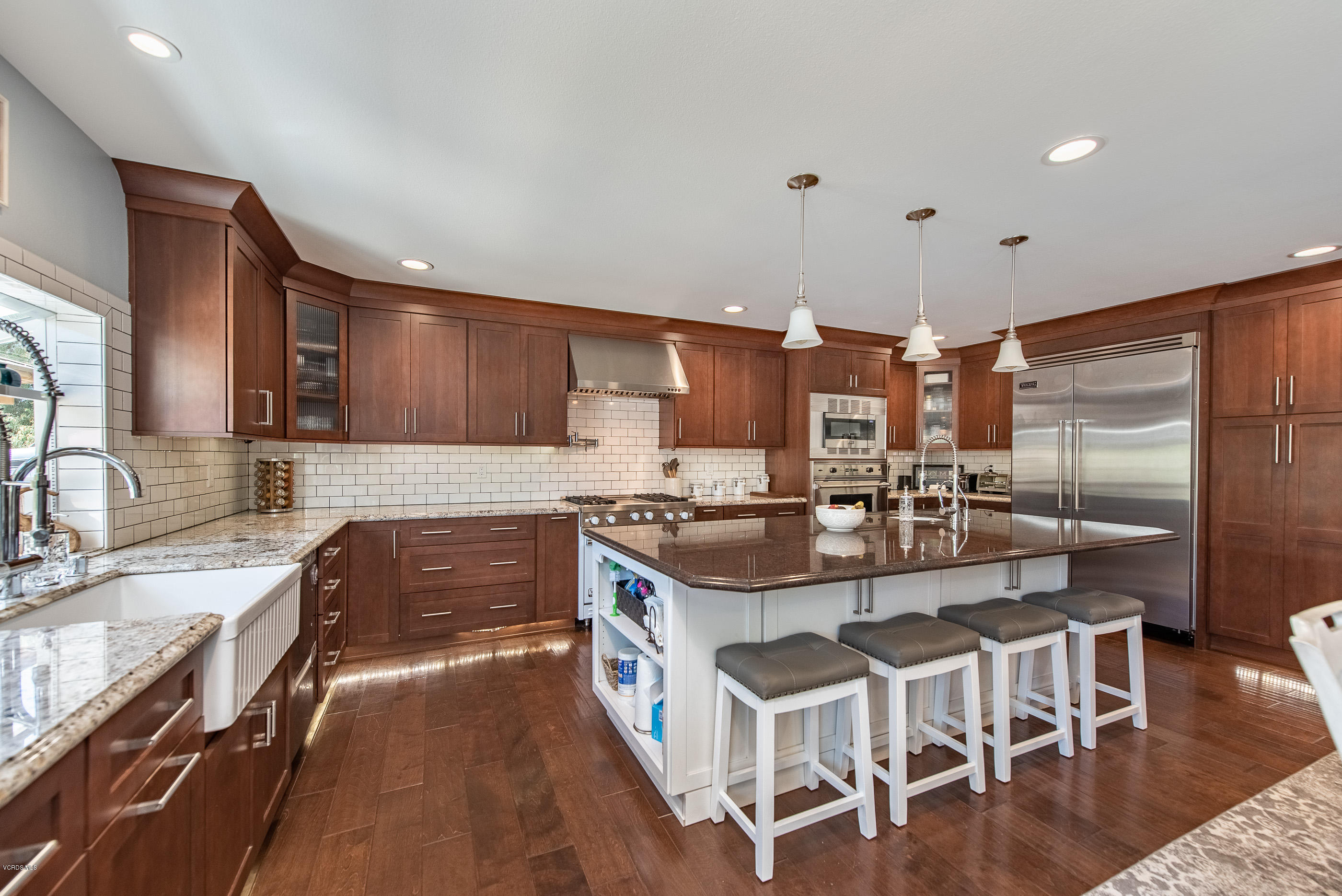 1242 Rambling Road Simi Valley, CA 93065 - Photo 11 of 81 a kitchen with stainless steel appliances granite countertop a stove top oven a sink a dining table and chairs